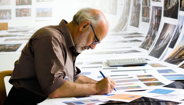 Old school ad man with his sleeves rolled up working on the creatives for a client on a marketing and advertising campaign